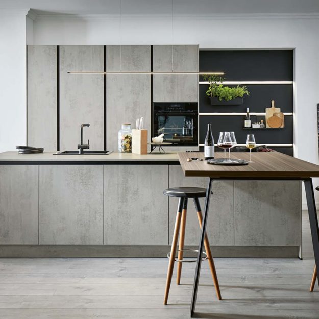 Moderne Küche mit Betonoptik-Fronten, integrierter Kücheninsel und angesetztem Holztisch, kombiniert mit offenen Regalen und stimmungsvoller Beleuchtung